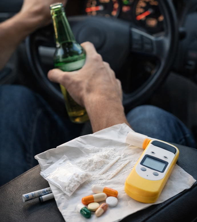 Avvocato guida stato di ebrezza: uomo al volante con birra, alcoltest, droghe. Rischio legale a Lodi e Piacenza. Immagine forte e chiara.